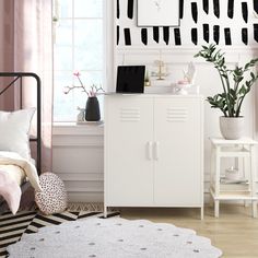 a bedroom with white furniture and black and white wallpaper on the walls, along with pink curtains