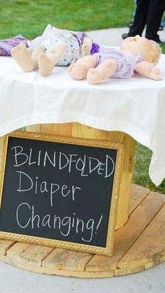 a sign that says, blindfold diaper changing on top of a wooden stand