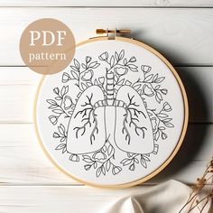 a cross stitch pattern with the image of a heart and lungs on it, surrounded by flowers