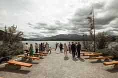 a group of people standing around wooden benches