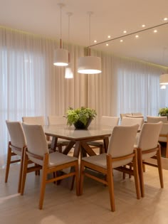 the dining room table is surrounded by white chairs