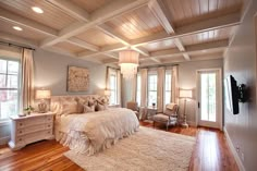 a large bedroom with wood floors and white walls, along with wooden flooring that matches the ceiling