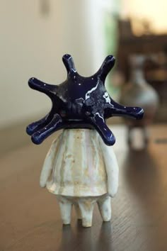 a ceramic figurine with a starfish on it's head sitting on a table