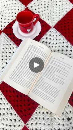 an open book sitting on top of a table next to a cup and saucer