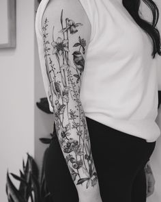 a woman's arm with flowers and birds on it