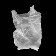 a white plastic bag is shown against a black background with the bottom half torn off