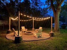 an outdoor fire pit surrounded by chairs and string lights