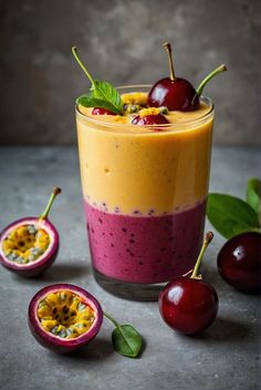 a smoothie in a glass topped with cherries and garnished with green leaves