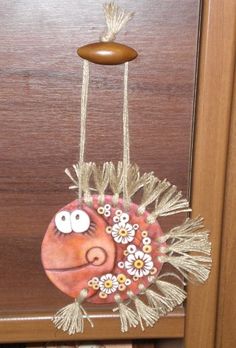 a fish decoration hanging from the side of a door with flowers on it's head