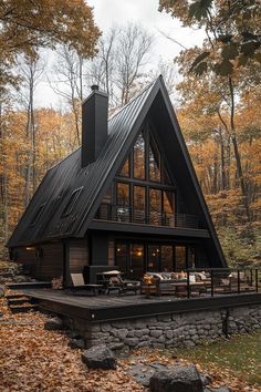 a - frame cabin in the woods surrounded by fall foliage