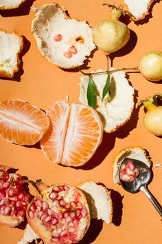 oranges, pomegranates and other fruit are arranged on an orange background