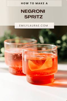 two glasses filled with red liquid sitting on top of a table