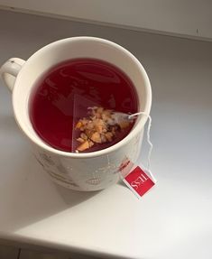 a cup of red liquid with some kind of food in it