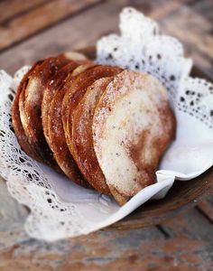 a basket filled with pastries on top of a white doily covered table cloth