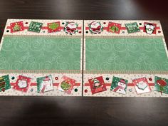 two christmas themed placemats sitting on top of a wooden table