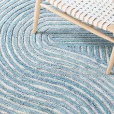 a blue and white rug on the floor with a wooden bench in front of it