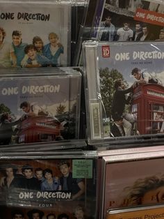 there are many dvd's on display in the store, including one direction and one direction