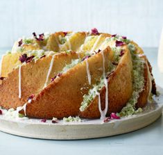 a bundt cake with white icing and sprinkles sitting on a plate