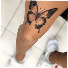 a woman's leg with a butterfly tattoo on it