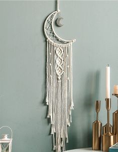 a crescent hanging on the wall next to candles and other items in front of it