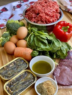 an assortment of meats and vegetables on a cutting board