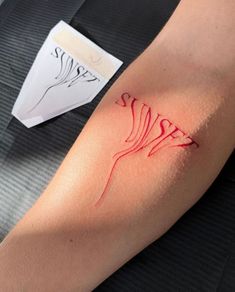 a woman's arm with red ink that has been drawn on it and is sitting next to a piece of paper