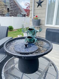 an outdoor table and chairs with water pouring out of the cup on it's top