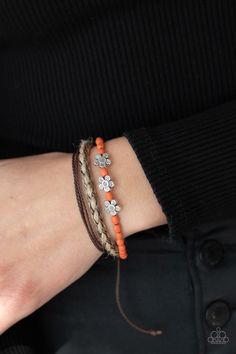 a woman wearing an orange and brown bracelet