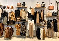 clothes and handbags are displayed on shelves in a store