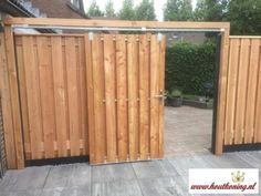 a wooden gate is open on a patio