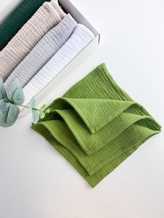 four folded towels are sitting next to each other in a box on a white surface