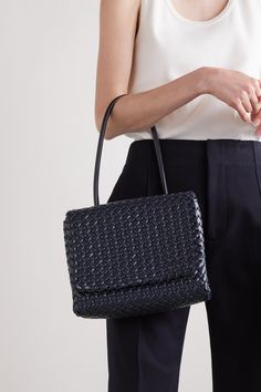 Bottega Veneta's 'Patti' bag is woven from leather in the brand's signature  intrecciato  pattern – each strip is lightly padded for volume. Shown on the Fall '22 runway, it has a compact foldover silhouette free from hardware or emblems. The graceful top handle is long enough to slip comfortably on your shoulder. Elegant Woven Leather Shoulder Bag For Travel, Elegant Leather Shoulder Bag With Intrecciato Weave, Designer Formal Bags With Interwoven Design, Classic Woven Leather Shoulder Bag For Office, Elegant Woven Leather Satchel Bag, Chic Business Shoulder Bag With Intrecciato Weave, Designer Woven Leather Square Bag, Designer Square Bag With Woven Leather, Designer Square Bags With Woven Leather