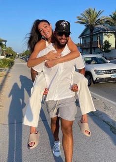 a man carrying a woman on his back down the street