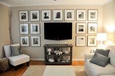 a living room with pictures on the wall and a television mounted to the wall above it