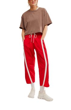 Traditionally sporty track attire gets a street-style reset in these water-resistant nylon pants refreshed with an ultrawide smocked waistband and wavy cropped hems. 25 1/2" inseam; 18" leg opening; 14" front rise; 18" back rise (size Medium) Smocked/drawstring waist Front scoop pockets; back patch pockets Water resistant 100% nylon Machine wash, tumble dry Imported Sporty Spring Joggers With Drawstring, Sporty Drawstring Joggers For Spring, Spring Sportswear Sweatpants With Elastic Side Panels, Sporty Nylon Pants With Drawstring, Sporty Nylon Joggers With Drawstring, Sportswear Sweatpants With Elastic Side Panels For Spring, Spring Sportswear Parachute Pants With Relaxed Fit, Relaxed Fit Parachute Pants For Spring Sportswear, Sporty Cotton Parachute Pants With Loose Fit