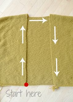 the back side of a knitted blanket with white arrows pointing up and down on it