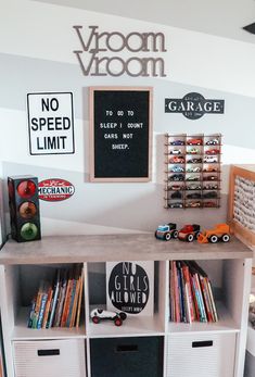 there is a book shelf with many books on it and some bins under the shelves