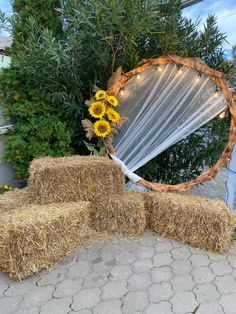 hay bales stacked on top of each other in front of a wreath and sunflowers