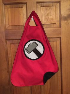 a red bag with a hammer on it hanging from a door