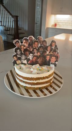 a cake on a plate with pictures of people cut out of the frosting and sitting on top of it