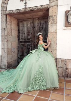 a woman in a green dress is posing for the camera