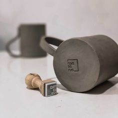 a coffee mug sitting on top of a table next to a couple of wine corks