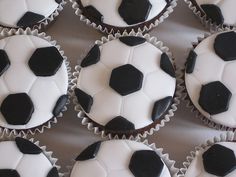 cupcakes decorated with black and white frosting are arranged in the shape of soccer balls