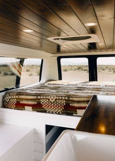 a bed in the back of a truck with wooden walls and flooring on it