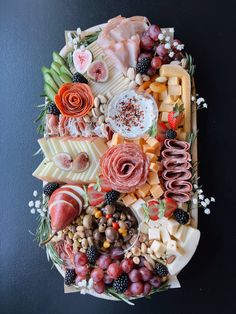 a platter filled with different types of cheeses and meats on top of each other