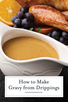 a white bowl filled with gravy next to oranges and blueberries