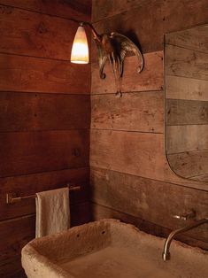 a bathroom with wooden walls and a sink