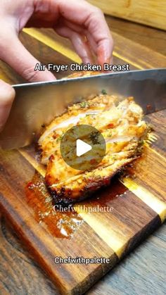 a person cutting up food on top of a wooden cutting board next to a knife