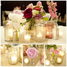 there are many vases with flowers in them and lit candles on the table top