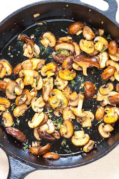 mushrooms are cooking in a skillet on the stove